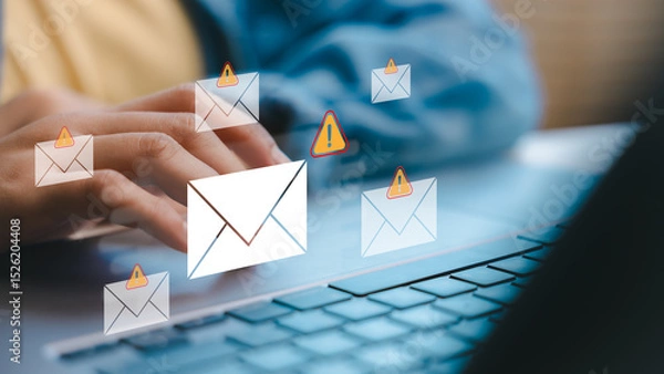 Obraz Hands typing on a laptop with warning email icons, representing phishing attacks, scam messages, and email security threats in a digital communication concept.
