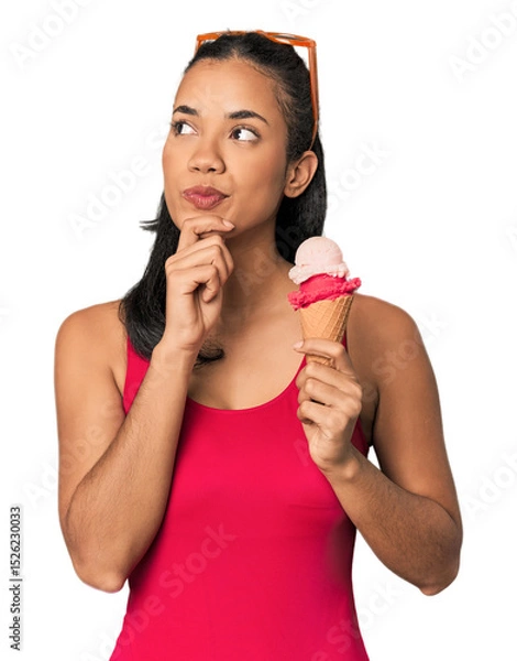 Fototapeta Young Filipina in bikini with ice cream looking sideways with doubtful and skeptical expression.