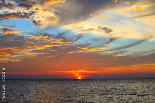 Fototapeta Colourful sunset over sea with it's reflection as background