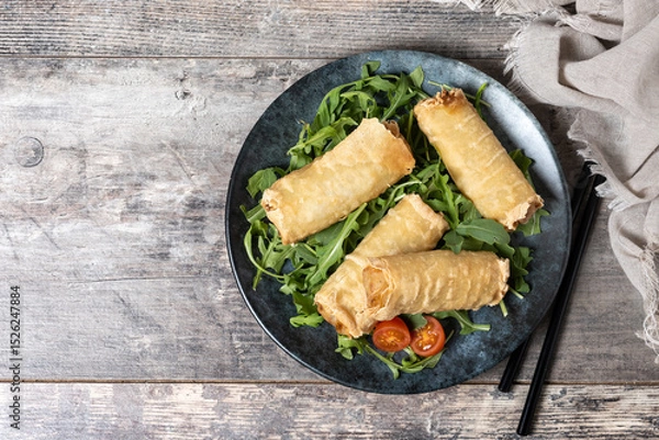 Fototapeta Crispy vegetables spring Rolls on wooden table. Top view. Copy space