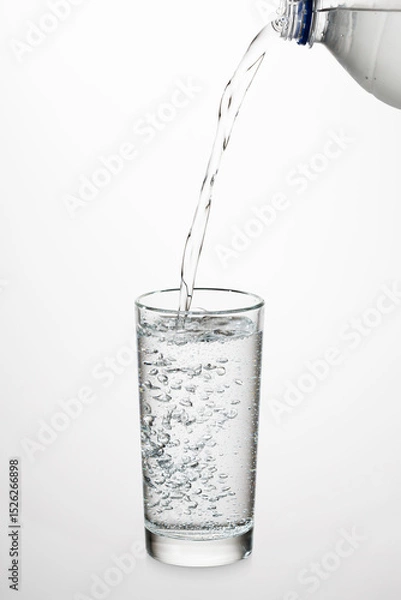 Fototapeta A refreshing stream of clear water pours into a transparent glass, capturing the essence of purity and hydration.