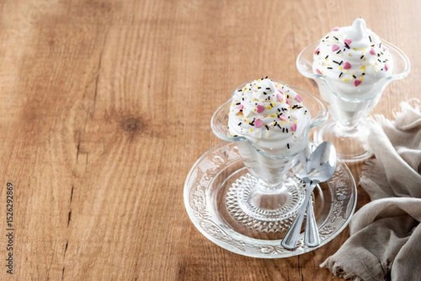 Fototapeta Whipped Cream Delight with Sprinkles on wooden table. Copy space