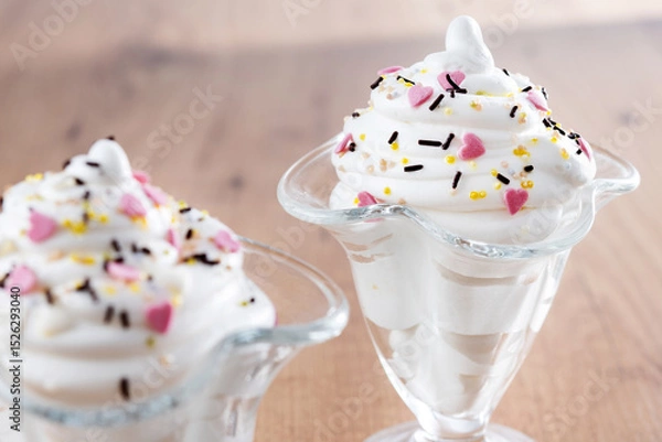 Fototapeta Whipped Cream Delight with Sprinkles on wooden table