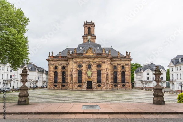 Obraz A large building Baroque church in the city of Saarbrucken in Germany with a clock tower and a small courtyard in front of it