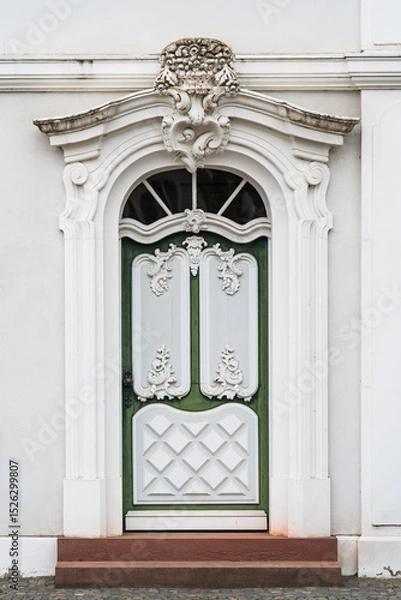 Obraz A green door with white trim sits in front of a white building in Saarbrucken Germany