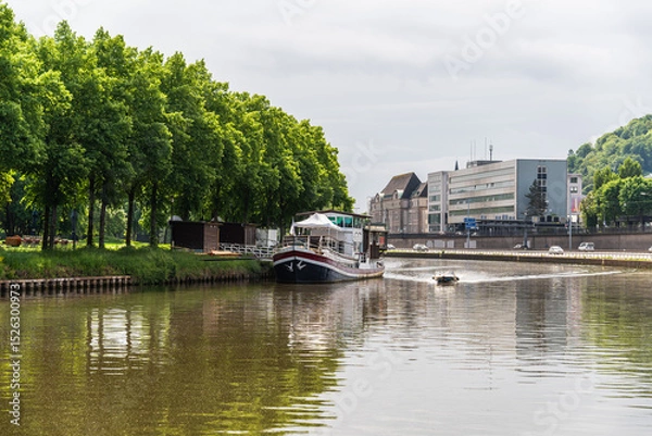 Obraz A boat is traveling down a Saar river near a Saarbrucken city in Germany