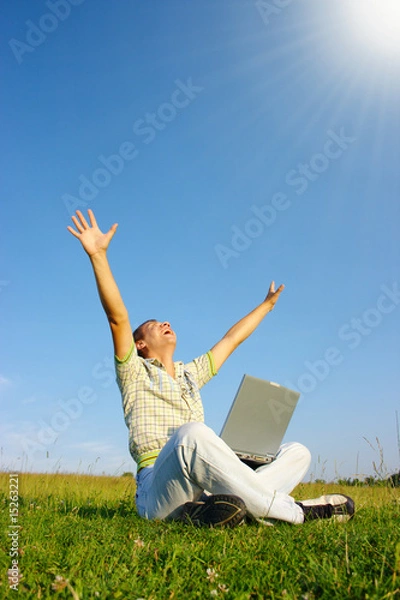 Obraz Happy student with laptop on green meadow