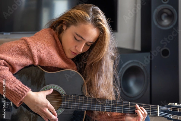 Obraz Teenage girl playing guitar at home. Guitar. Stringed musical instrument.