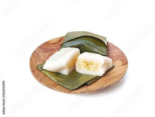 Fototapeta Papais or Nagasari cake on wooden plate. Indonesian food made from raw rice and glutinous rice wrapped in banana leaves. isolated on white background 