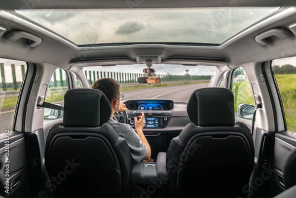 Obraz Car interior with panoramic roof. Driver on highway. Road trip.
