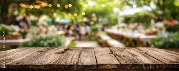 Fototapeta Rustic Wooden Table Overlooking an Outdoor Garden Setup with Blurred Background of Event Decor and Soft Ambient Lighting