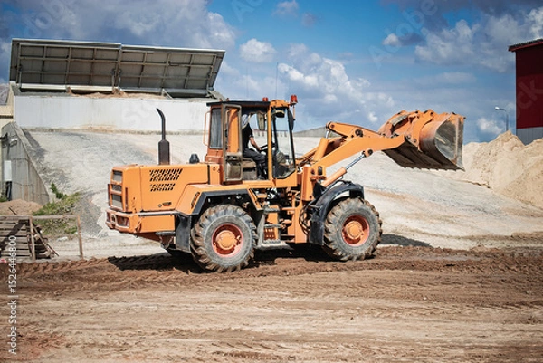 Obraz Heavy machinery working at a construction site for earth moving and material handling during a sunny day