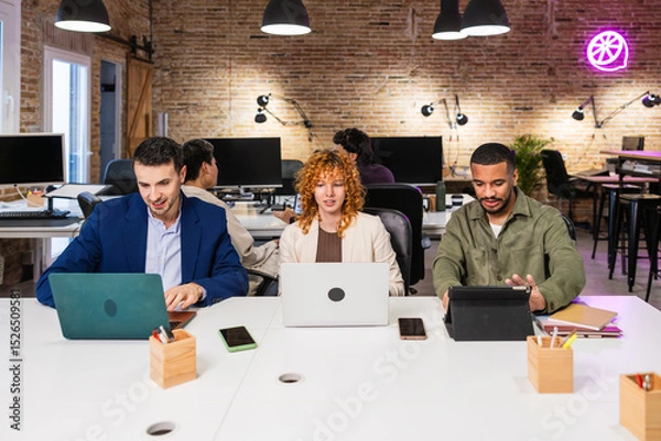 Fototapeta Multi ethnic team working together on project in modern office