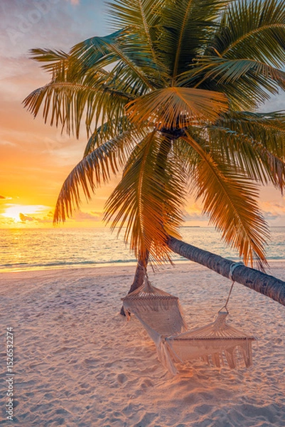 Fototapeta Closeup sunset view palm tree with hammock swing over golden sand sea. Romantic inspire carefree tropical landscape with vivid sky, perfect for summer vacation, relaxation, and dreamy beach background