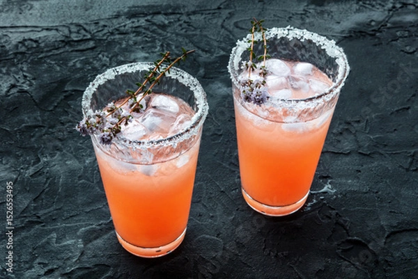 Fototapeta Salty Dog cocktail with fresh grapefruit juice, lime juice, and thyme, on a black slate background