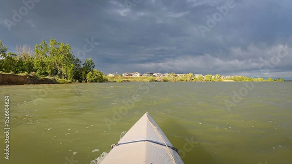 Obraz paddling under stormy sky - POV view from paddling kayak or canoe on Boedecker Reservoir in Loveland, Colorado