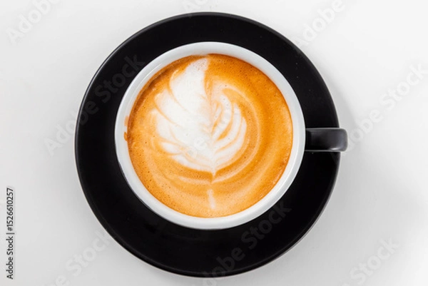 Fototapeta Top View of Fresh Cappuccino with Leaf Latte Art in Black Cup on White Table. Cozy Morning Coffee.  Cafe Beverage, Coffee Break