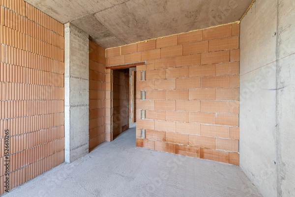 Fototapeta  Interior of Unfinished Apartment with Brick Walls and Concrete Ceiling – Under Construction Residential Building, Real Estate Development, Industrial Architecture Background