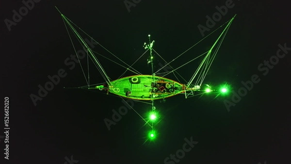 Obraz Green lights from a squid fishing boat create a mesmerizing scene on the dark waters near Koh Ma Beach, Koh Phangan Island, Thailand, attracting squid with their bright glow