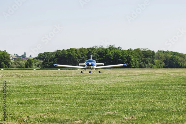 Fototapeta An airplane on a grass runway. The aircraft is ready to fly. It's a transportation for people
