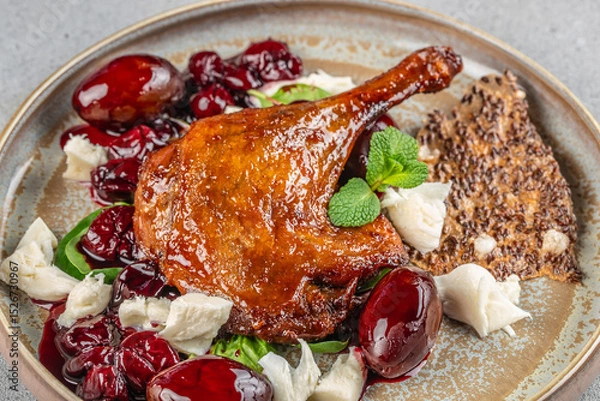 Obraz Roasted duck leg served with cherry sauce, soft cheese, and seed crispbread.