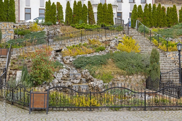 Fototapeta Waterfalls Stream in Hill Garden With Stones at Spring Day