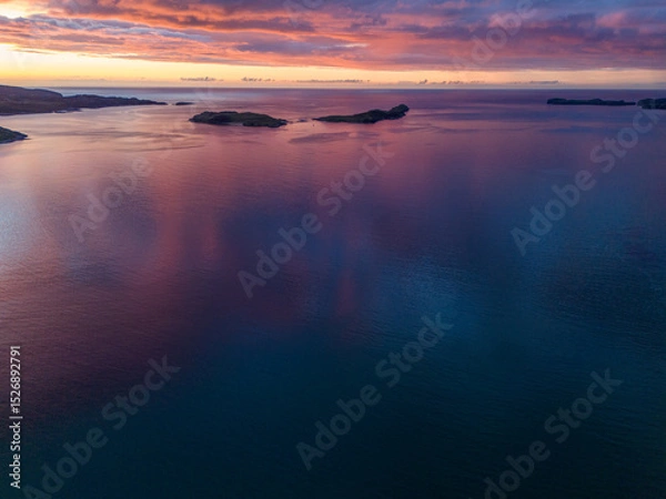 Fototapeta Aerial view of the sea at sunset with islands in the distance