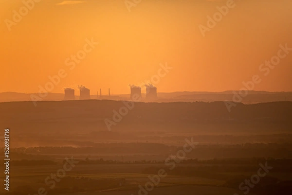 Obraz Dukovany Nuclear Power Plant at sunset with steam rising from cooling towers, set in a scenic landscape. Perfect for energy, industry, and environmental themes.