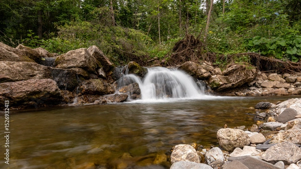Obraz Mountain stream waterfall in Belianske Tatras, Slovakia. Scenic nature with rocks, clear water, forest background. Long exposure landscape perfect for travel and nature themes.
