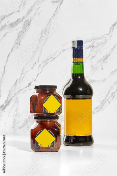 Fototapeta Baba preserving jars and borsci elixir bottle displayed on white marble surface
