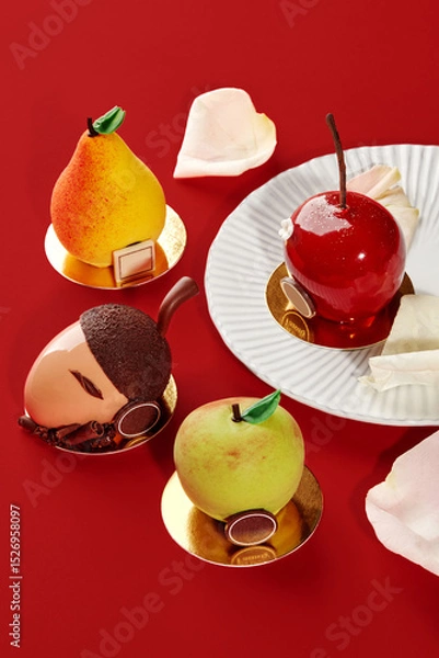 Fototapeta Delicious fruit shaped cakes resembling apple, pear, cherry and acorn on red background