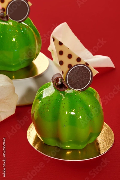 Fototapeta Delicious green pumpkin-shaped mousse cakes with mirror glaze on red background