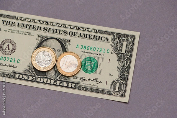 Fototapeta Unique collection of currency featuring a one dollar bill and foreign coins on a purple background
