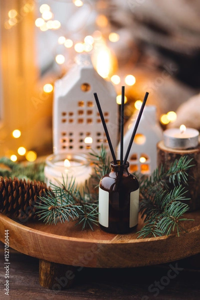 Obraz Creating cozy holiday Christmas home atmosphere. Liquid reed diffuser with sticks with xmas scent: vanilla, gingerbread cookies, pine, sweet pie, cinnamon, anise. Aromatherapy, wellness, relaxation