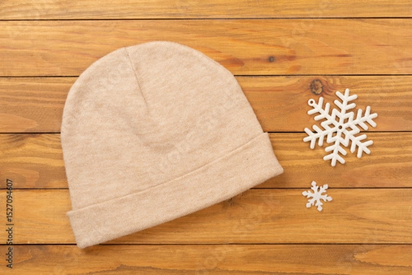 Fototapeta Stylish beanie hat on wooden background, top view