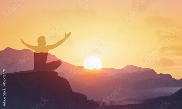 Fototapeta Young man facing mountain sunset rejoices, smiles looking up to the sky, enjoys life and summer, nature, happiness.