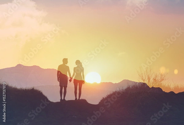 Fototapeta silhouette of a couple walking in the mountains talking  holding hands enjoying nature together 