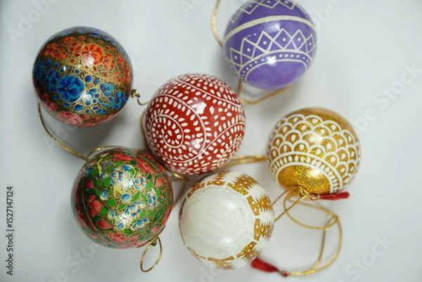 Fototapeta Hand-painted papier-mâché Christmas goodies by Kaar Kash, featuring stars, bells, trees, and more—crafted for hanging on Christmas trees and adding artisanal charm to festive décor.

