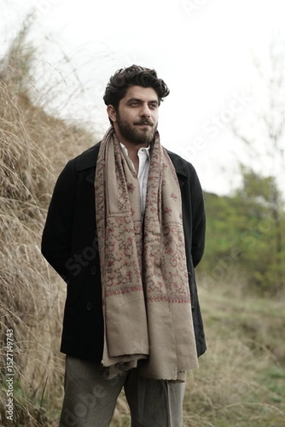 Fototapeta A Kashmiri model dressed in a traditional shawl and vintage-style pheran, posing for a Kaar Kash shoot that highlights timeless craftsmanship and the cultural soul of Kashmir.

