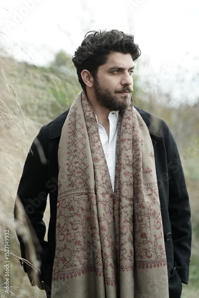 Fototapeta A Kashmiri model dressed in a traditional shawl and vintage-style pheran, posing for a Kaar Kash shoot that highlights timeless craftsmanship and the cultural soul of Kashmir.

