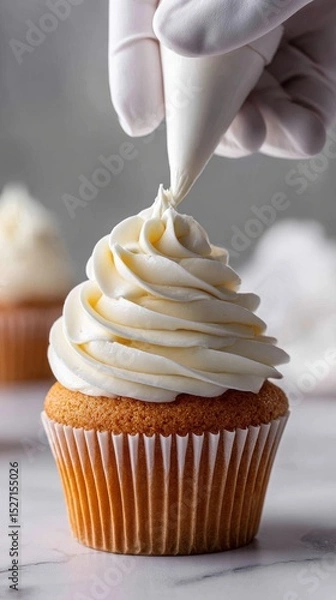 Fototapeta  Mid-piping moment: smooth buttercream curls onto a cupcake, with gloved hands gently squeezing. Soft light and a clean kitchen counter create a serene scene.  