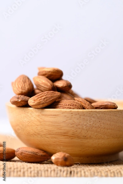 Obraz Raw almond nut seed in wooden bowl with white background, Food ingredient
