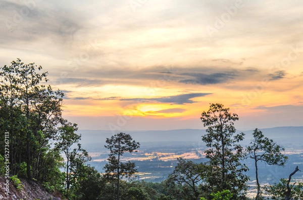 Obraz Beautiful view of the sunrise, light through the clouds on the mountain top, reflecting on the water in the rice fields, rural area of ​​Phayao Province, Northern Thailand.
