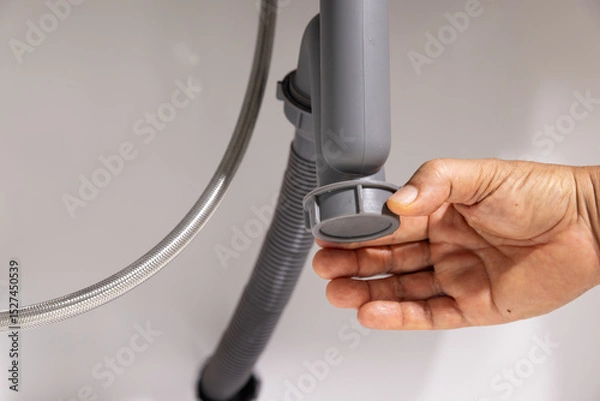 Fototapeta Plumber open trap to fixing drain clog under sink.