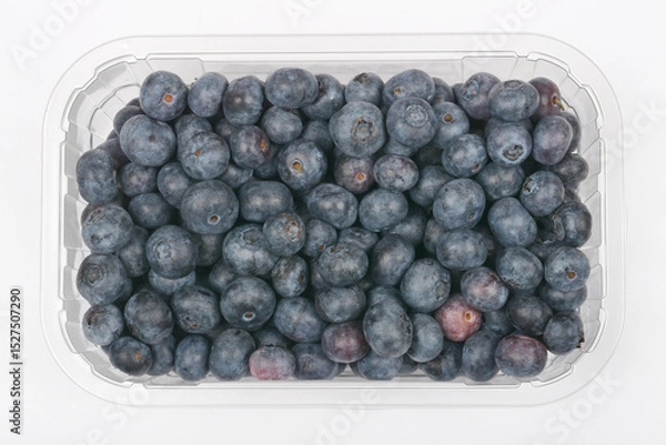 Obraz A plastic container filled with fresh, ripe blueberries is viewed from above against a neutral background