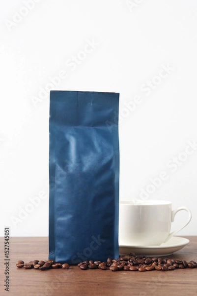 Fototapeta Blue blank coffee bag on wooden table. Packaging mockup with empty space for you designs.