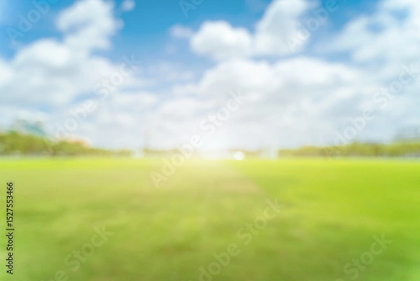 Fototapeta Beautiful blur green grass field background against summer sky with clouds on a bright sunny day