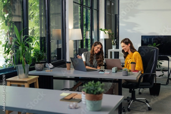 Fototapeta Gen z colleagues working together in modern office using laptops