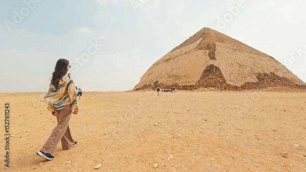Fototapeta Tourist walking towards the bent pyramid in the desert of dahshur, egypt