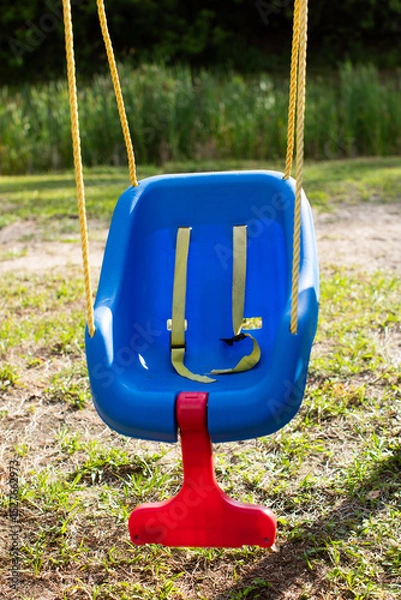 Fototapeta an empty safe blue plastic babies and children's swing on a playground